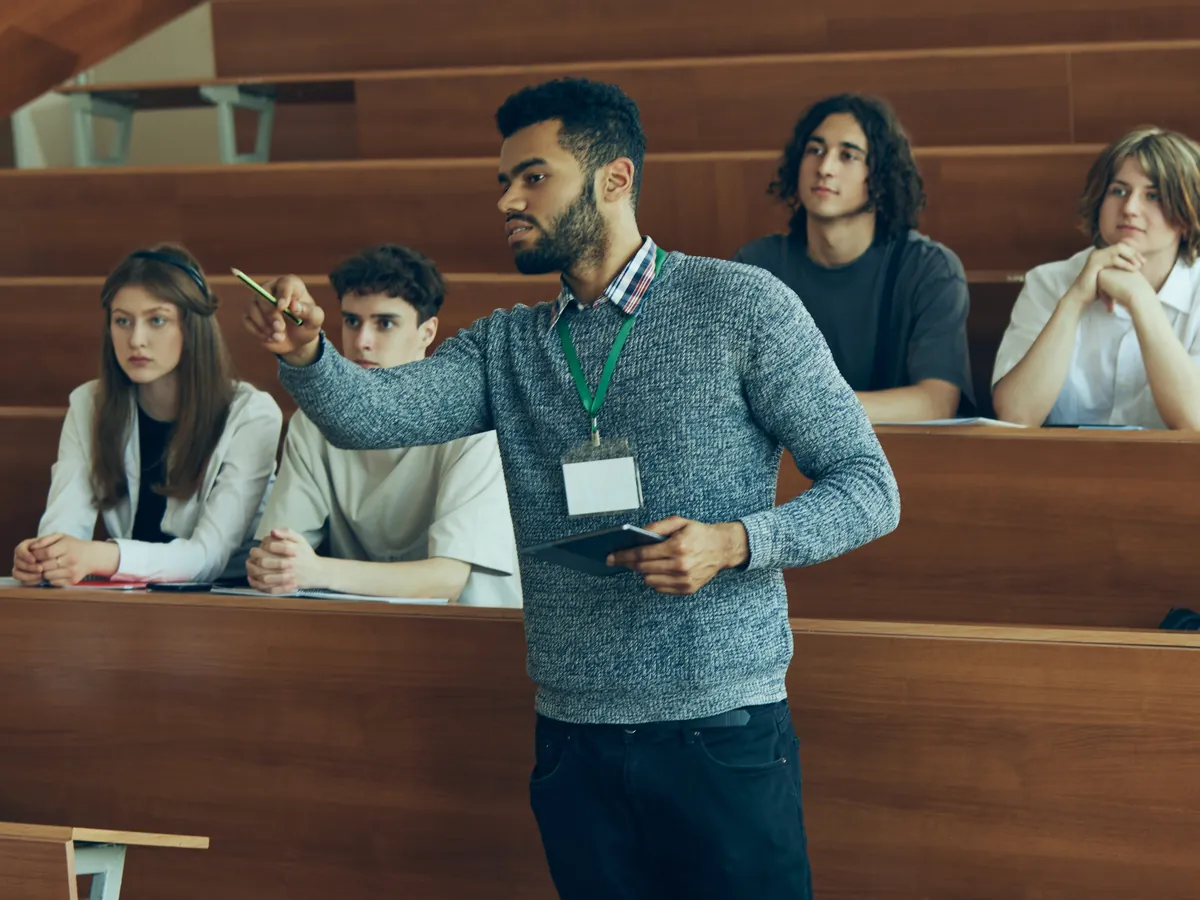 Instructor leading an engaged discussion with students in a university lecture hall